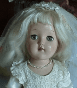 Porcelain doll wearing pearl necklace