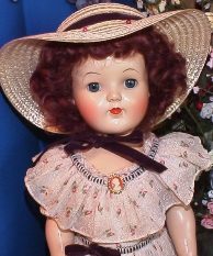 Vintage doll with curly hair and hat
