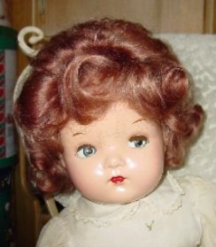 Vintage doll with curly red hair and blue eyes.