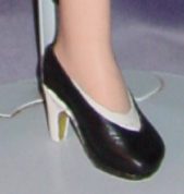 Close-up of a black high-heeled shoe on a mannequin leg.